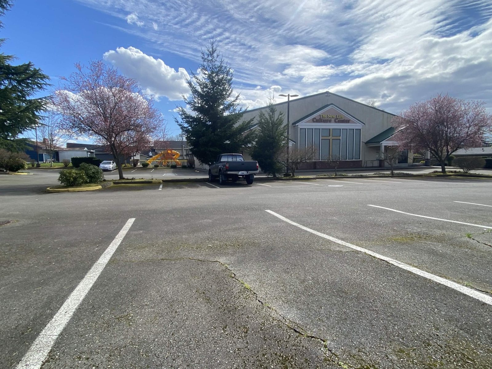 The New Life Culture Center seen from its parking lot, cherry trees in bloom