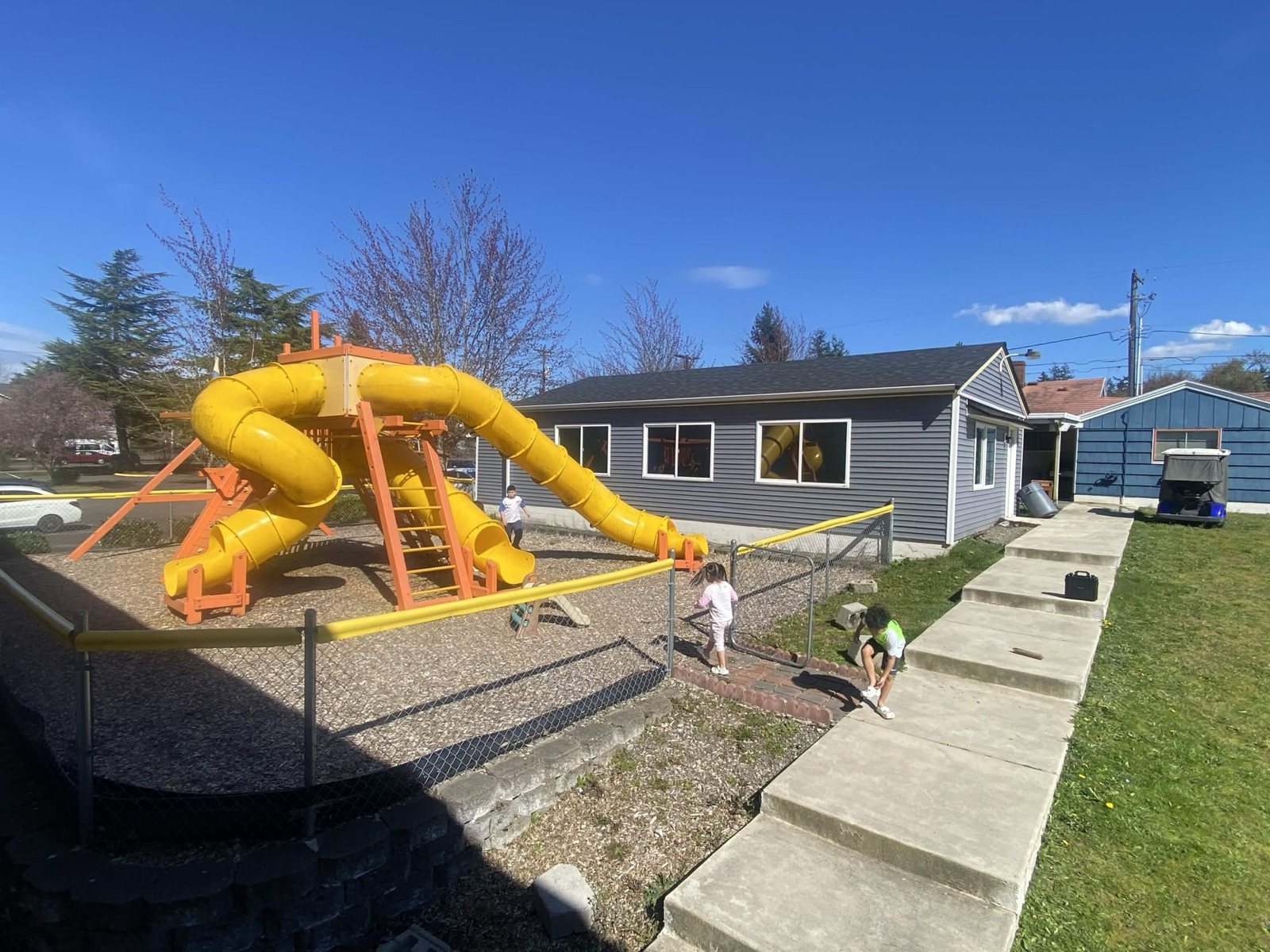 A yellow tube slide on the playground beside the center