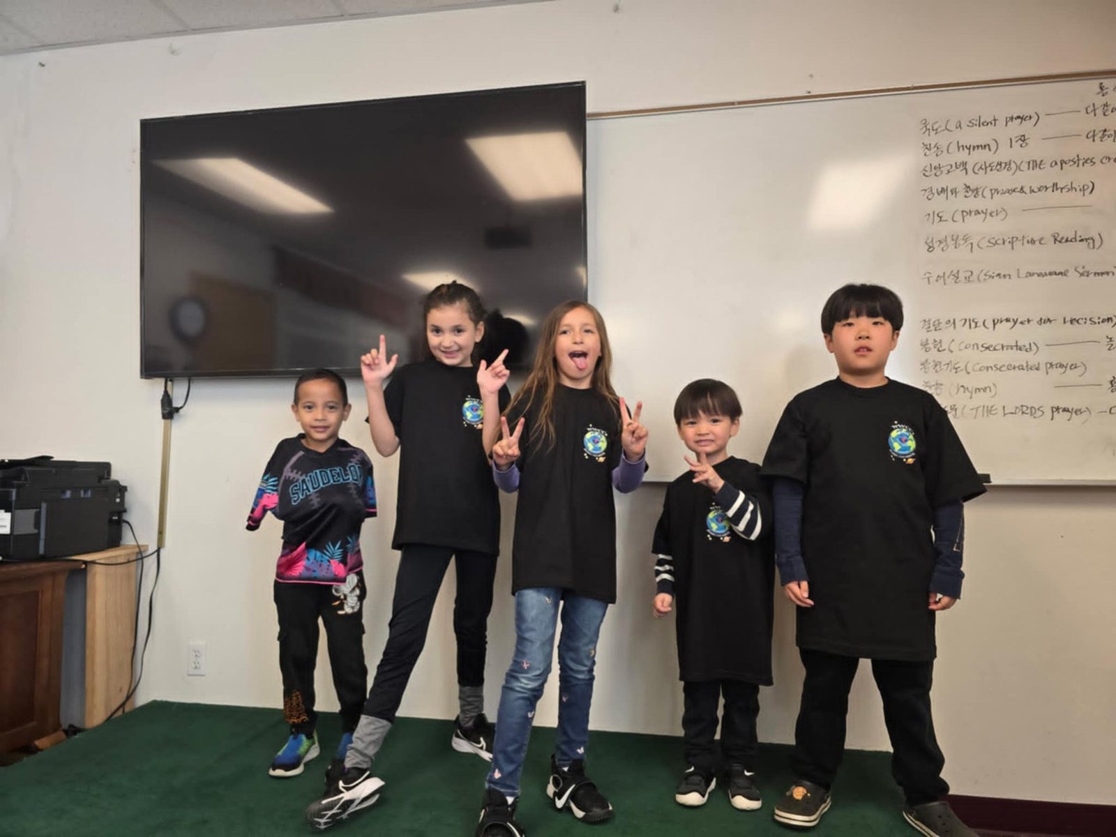 Students pose in front of the classroom whiteboard