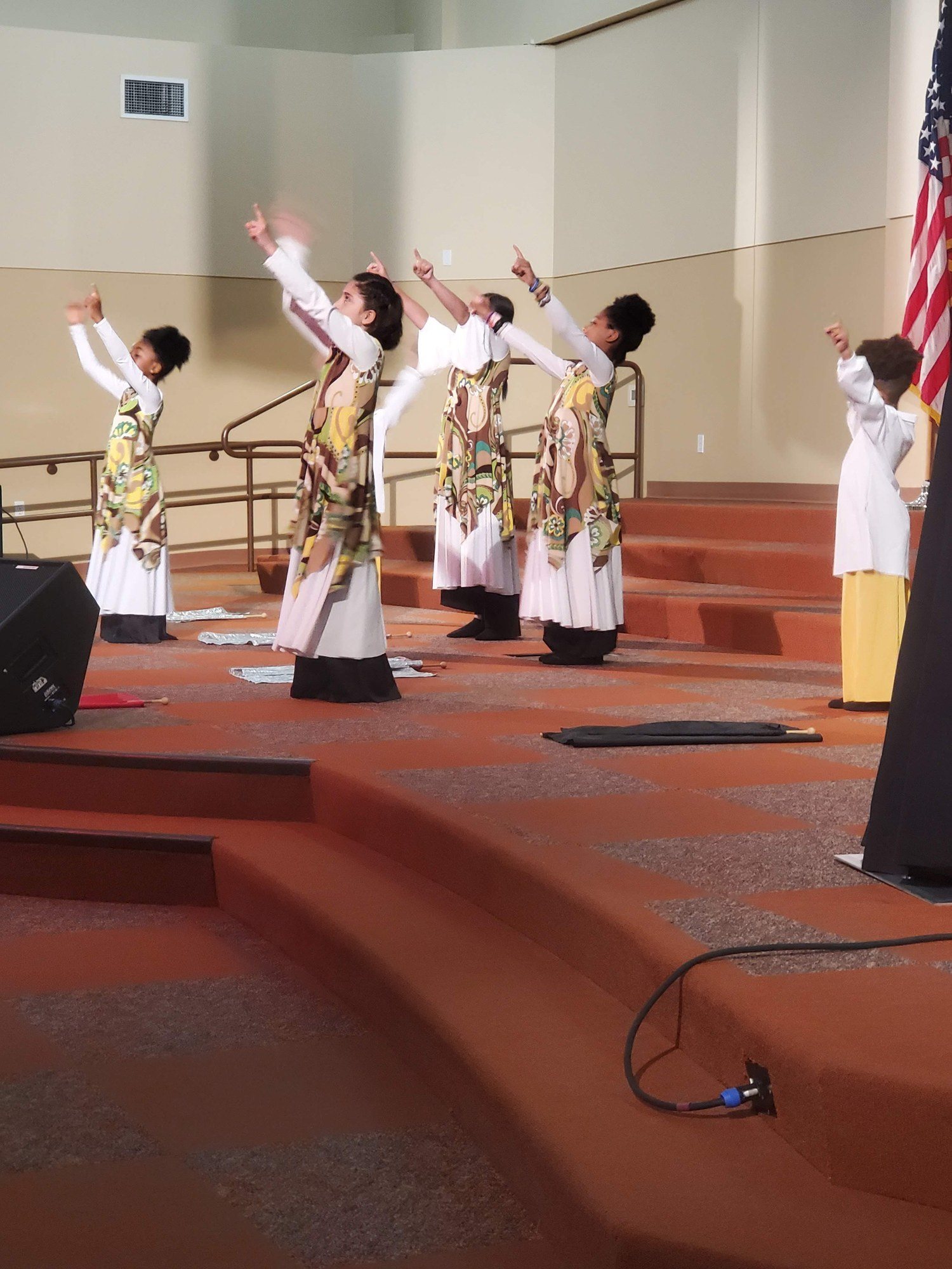 Young dancers on stage with their arms raised