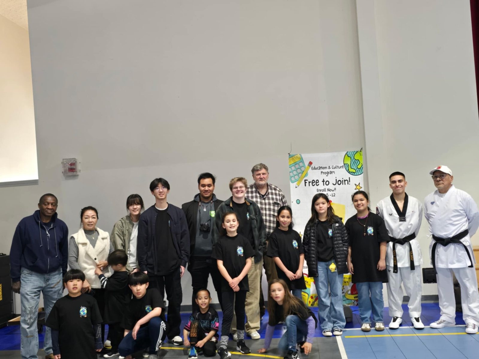 Students and instructors in uniform pose for a group photo in the gym